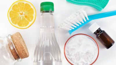 Eco-friendly natural cleaners. Vinegar, baking soda, salt, lemon and essential oil. Homemade green cleaning on white background.